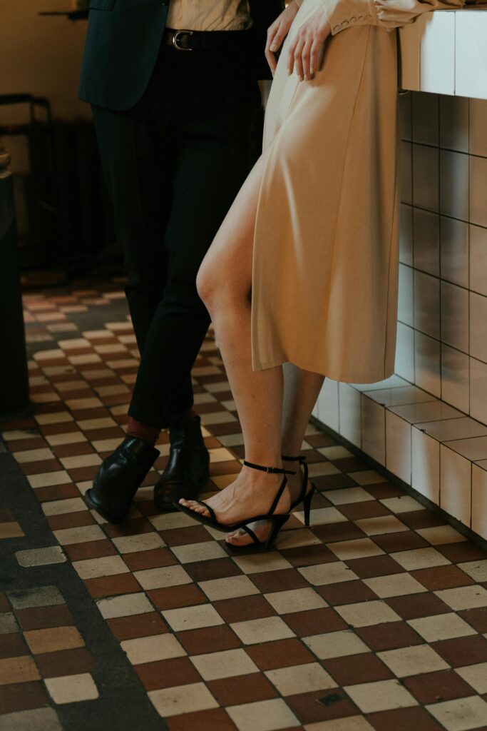 pexels-photo-4694559-4694559 An elegant couple stands at a tiled bar counter, showcasing a stylish and sophisticated appearance.